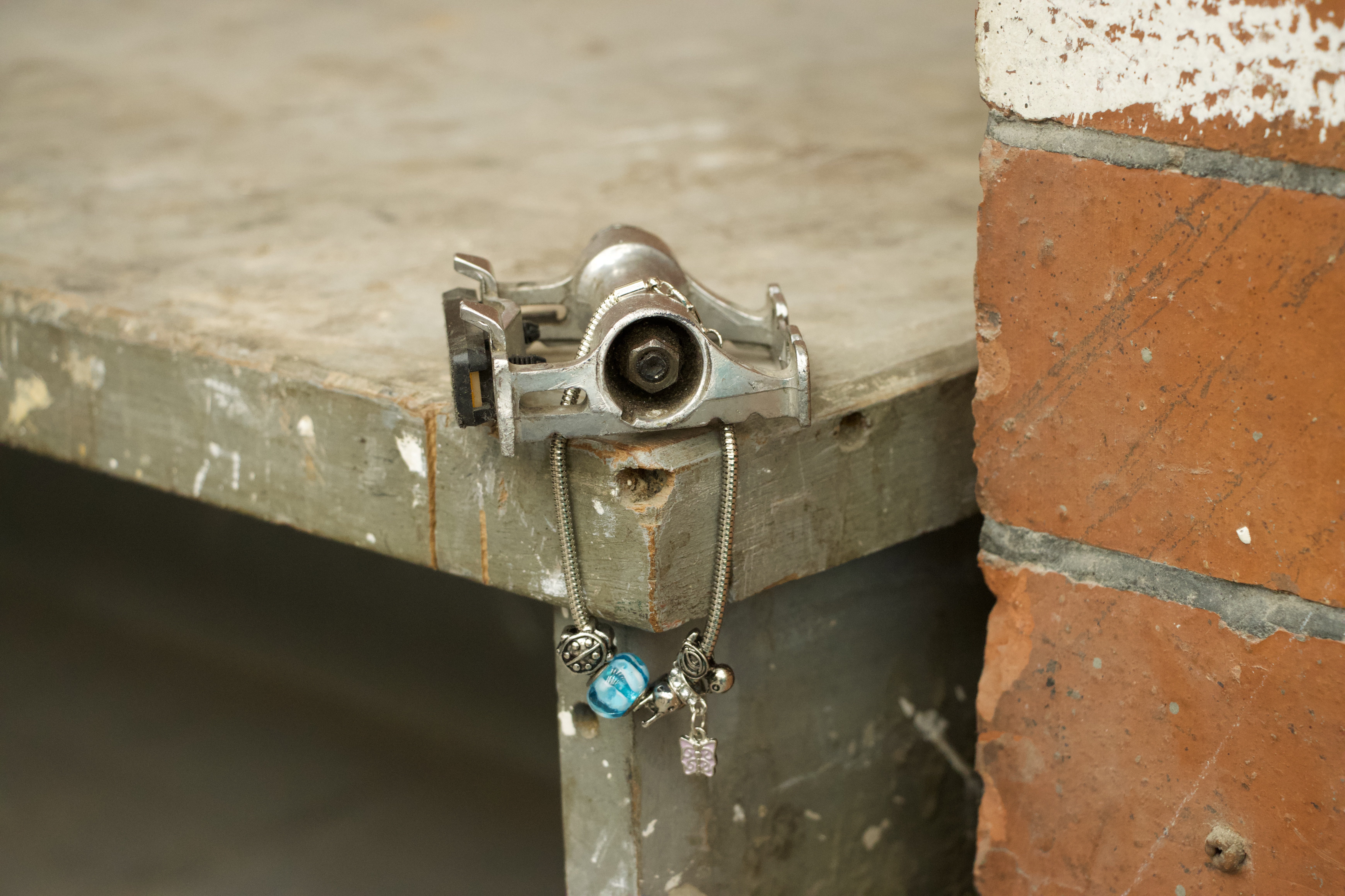 a bike pedal with a charm bracelet looped through it