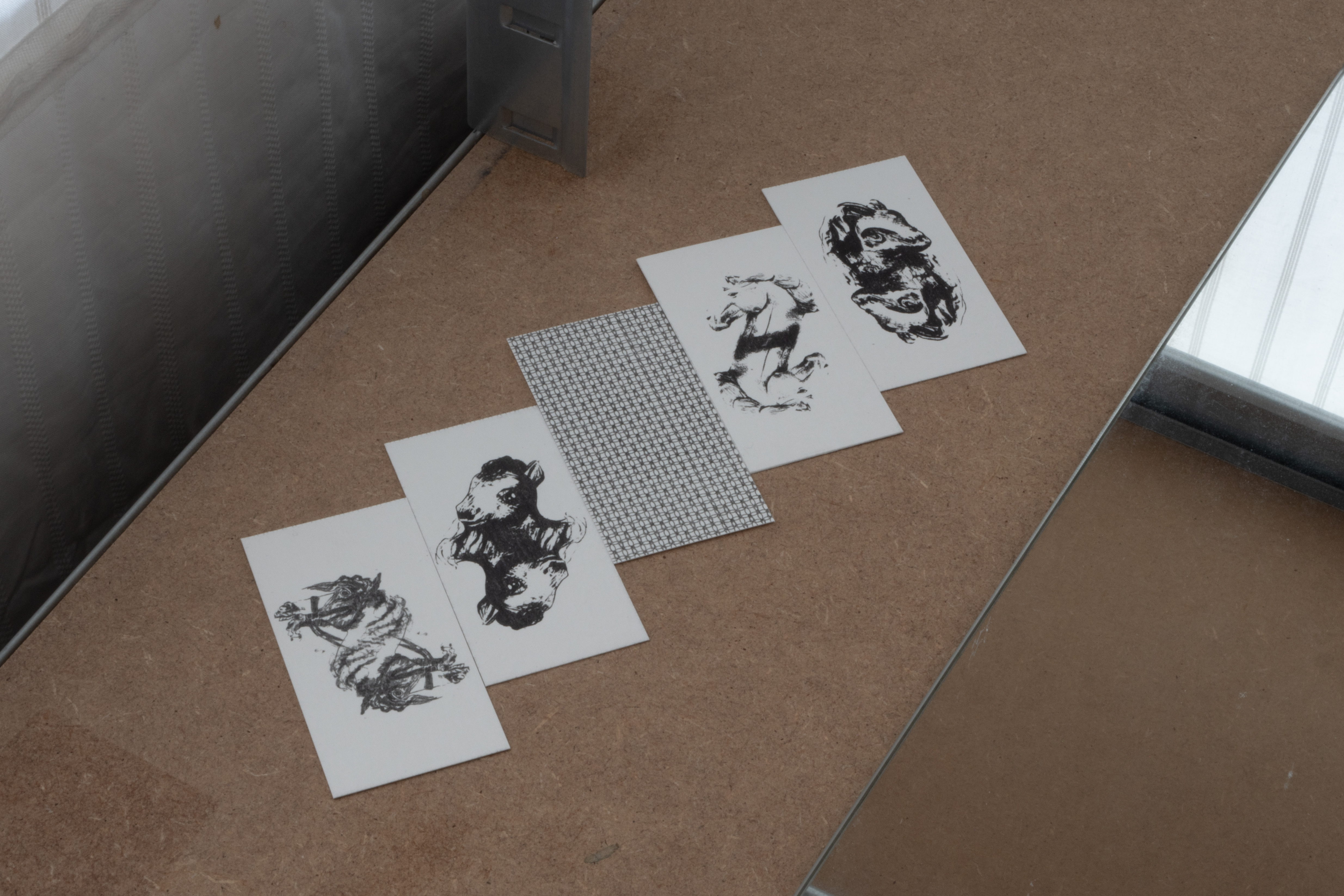 five cards laid out in a row, four face up showing horses head designs